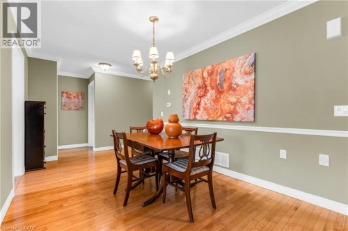 Dining area featuring wood-finish flooring, crown molding, and chair rail detailing - 50 Spadara Drive, Hamilton, ON - Indoor Photo Showing Dining Room