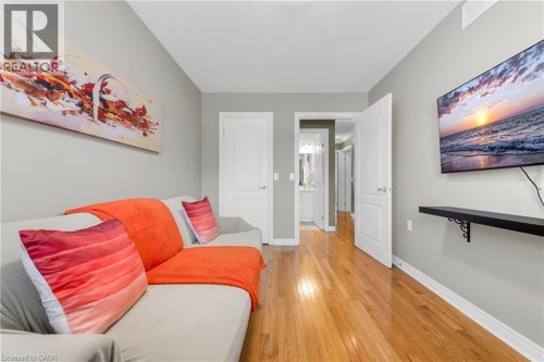 Warm wood-finish flooring extending into a hallway - 50 Spadara Drive, Hamilton, ON - Indoor