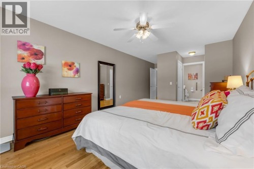 Bedroom featuring hardwood flooring, a ceiling fan with integrated lighting, and neutral wall tones - 50 Spadara Drive, Hamilton, ON - Indoor Photo Showing Bedroom