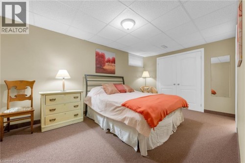 Spacious room featuring neutral painted walls, textured ceiling, brown carpeting, and white bi-fold closet doors - 50 Spadara Drive, Hamilton, ON - Indoor Photo Showing Bedroom