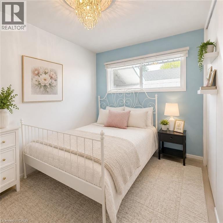 Light-filled room featuring a crystal chandelier and a prominent window with white blinds - 82 Blackwood Crescent, Hamilton, ON