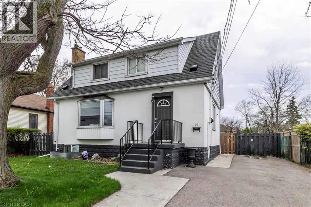 Two-story residence featuring a gray asphalt shingle roof and light-colored siding - 20 West 1St Street, Hamilton, ON