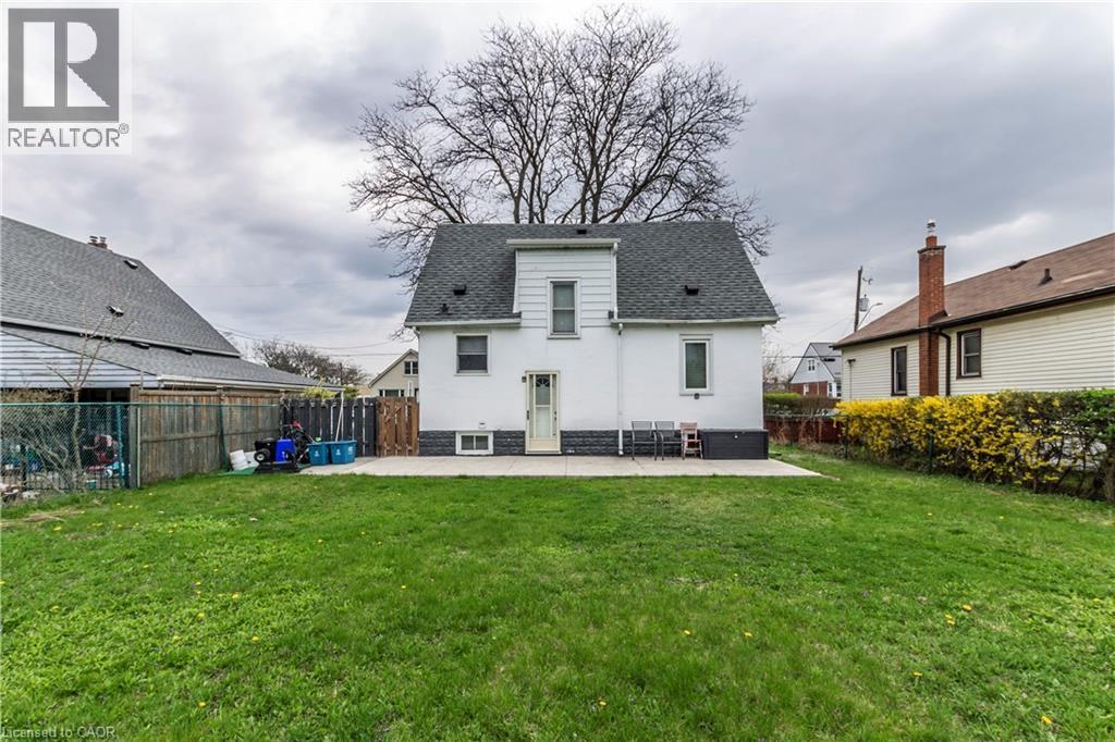 Expansive green lawn with a concrete patio - 20 West 1St Street, Hamilton, ON