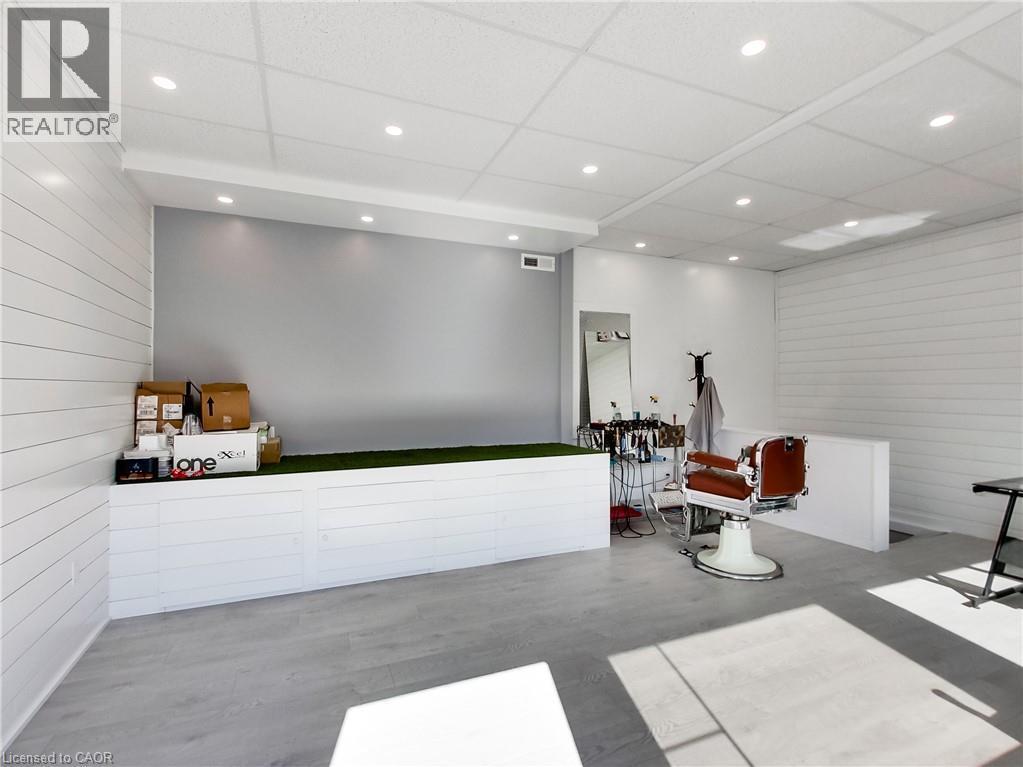 Spacious interior featuring wood-finish flooring, white shiplap walls, and recessed ceiling lighting - 229 Parkdale Avenue N, Hamilton, ON
