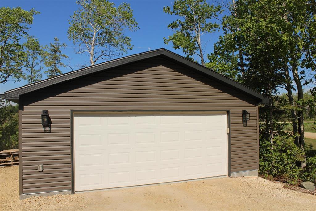 Garage measures 26.4 x 24.4. Has a "smart" garage door opener that you can open with your phone! Great for additional storage and perfect for Manitoba winters. - 7 Dalvik Road, Gimli Rm, MB