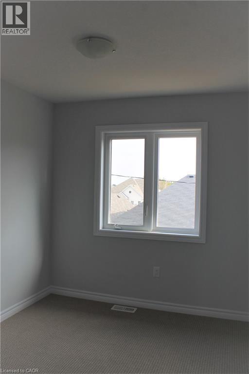Neutral wall finishes and a double window provide a bright interior - 124 Compass Trail Unit# 14, Cambridge, ON