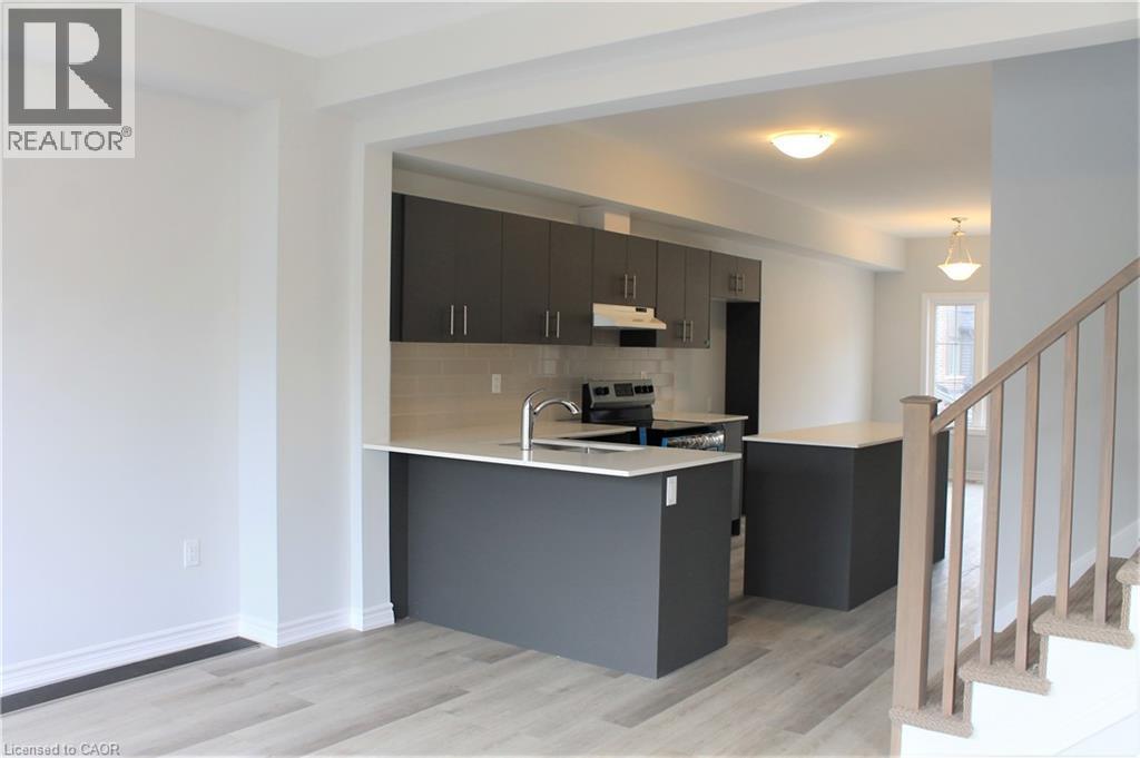 Modern kitchen featuring gray cabinetry, light countertops, and a subway tile backsplash - 124 Compass Trail Unit# 14, Cambridge, ON