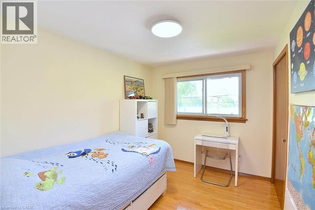 Room with wood-finish flooring, a window with wood trim, and a flush-mount ceiling light - 372 Fennell Avenue W, Hamilton, ON