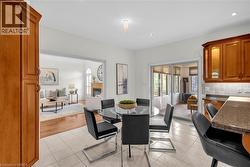 Kitchen-dining area featuring light-toned tile flooring, recessed lighting, and a chandelier fixture -