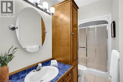 Bathroom vanity with an oval mirror and chrome lighting fixture -