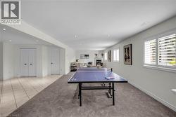 Spacious room featuring recessed lighting, multiple windows with white plantation shutters, and a partial carpet flooring -