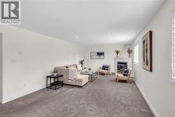 Living space featuring a corner fireplace with white mantel, recessed lighting, and carpet flooring -