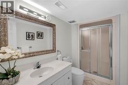 Vanity with integrated sink, chrome faucet, and ornate framed mirror -
