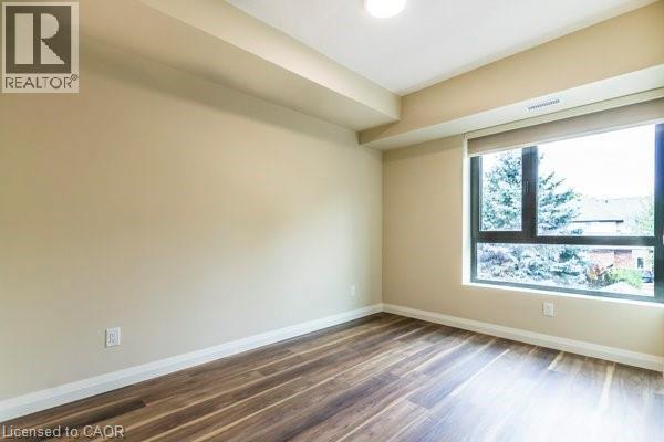 Unfurnished room with baseboards and dark wood finished floors - 580 Coldstream Drive Unit# 307, Waterloo, ON