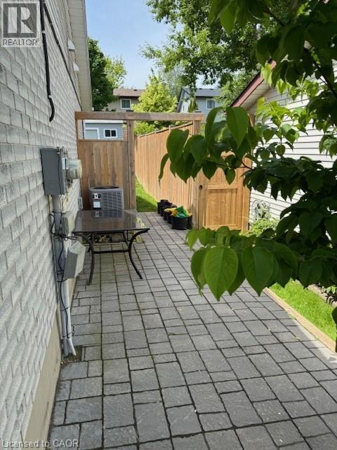 Paver patio with a full privacy fence and an external air conditioning unit - 113 Cornerbrook Crescent Unit# 2, Waterloo, ON