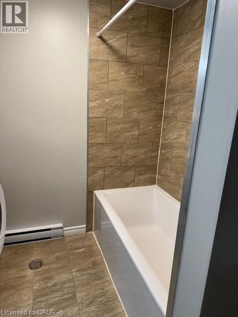 Bathroom featuring a white bathtub with a tiled surround - 113 Cornerbrook Crescent Unit# 2, Waterloo, ON