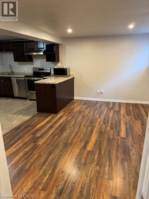 Kitchen area featuring dark wood cabinetry, stainless steel appliances, and a light-toned countertop - 113 Cornerbrook Crescent Unit# 2, Waterloo, ON
