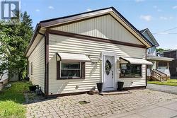 Cream-colored siding exterior with dark brown trim accents -
