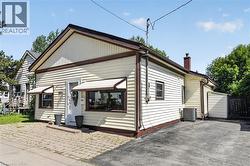 Siding exterior with contrasting trim, featuring multiple windows with awnings -