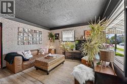 Living area featuring textured walls, black trim, and wood-finish flooring -