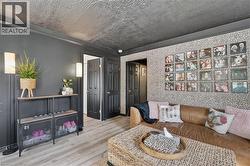 Interior space featuring textured walls, wood-finish flooring, and black paneled doors -
