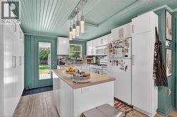 Kitchen featuring wood-finish flooring, a full-lite exterior door, and a planked ceiling -