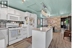 Kitchen featuring white cabinetry, a gas range, and a central island with a solid surface countertop -
