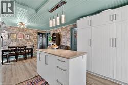 Kitchen island with a light-toned countertop and white cabinetry featuring silver-toned hardware -
