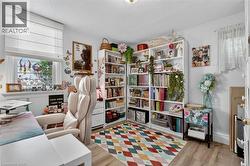 Built-in shelving for extensive storage, wood-finish flooring, and natural light from a window with white Roman shades -