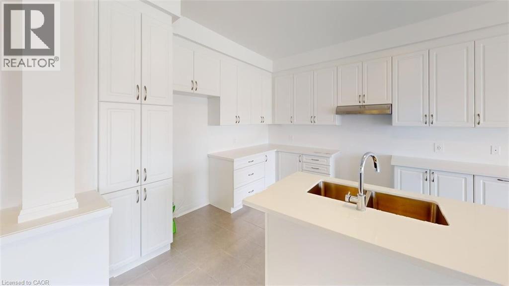 Kitchen featuring white cabinetry, light-toned flooring, an island with a stainless steel double sink, a chrome faucet, and a stainless steel range hood - 287 Rockledge Drive, Hamilton, ON
