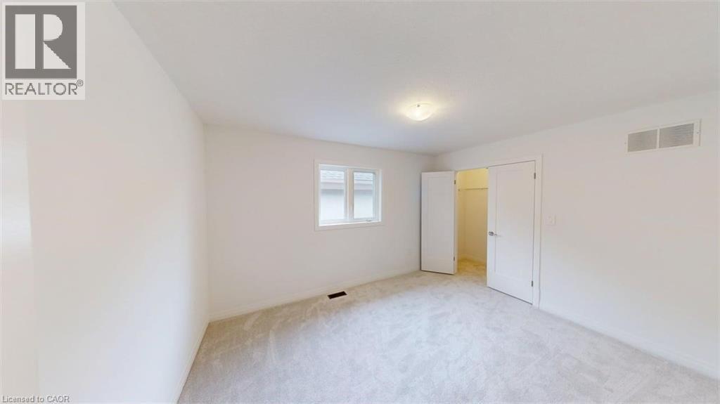 Carpeted room featuring light-colored walls, a single window, and a flush-mount ceiling light fixture - 287 Rockledge Drive, Hamilton, ON