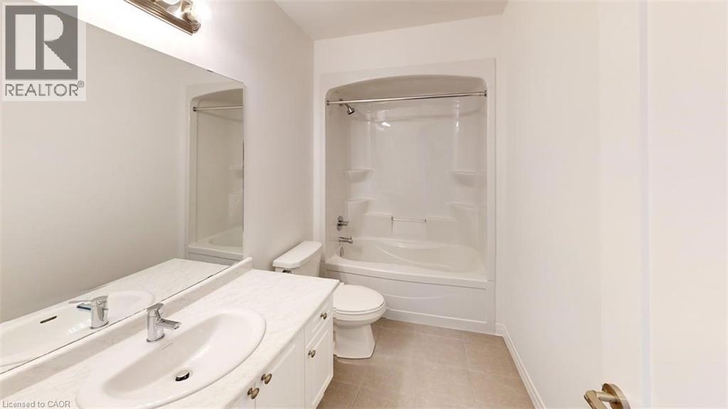 Bathroom featuring an integrated bathtub and shower unit, a white vanity with an undermount sink, a large wall-mounted mirror, and tile flooring - 287 Rockledge Drive, Hamilton, ON