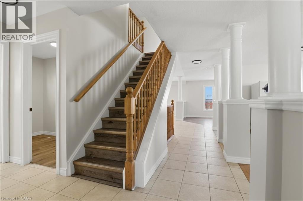 Staircase with wood-finish treads and natural wood balusters - 43 Decaro Crescent, Cambridge, ON