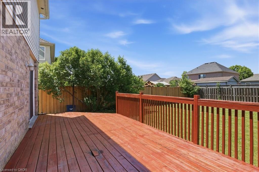 Expansive wood deck with a red stain finish, featuring a matching railing system - 43 Decaro Crescent, Cambridge, ON