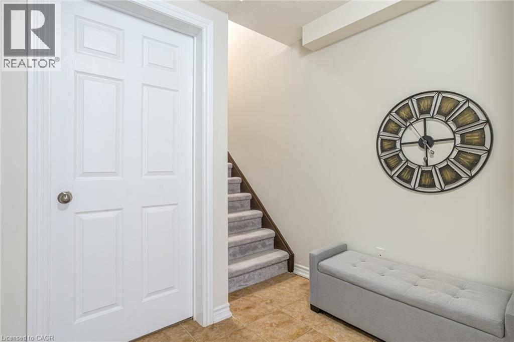 Entryway featuring a paneled interior door, tiled flooring, and carpeted stairs with dark wood risers - 7 Sirente Drive Unit# 11, Hamilton, ON - Indoor Photo Showing Other Room
