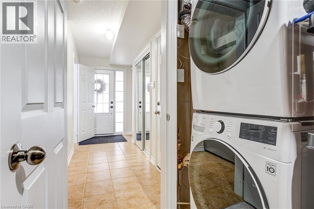 Entryway featuring tile flooring, white paneled doors, and a front entry door with sidelights - 7 Sirente Drive Unit# 11, Hamilton, ON - Indoor Photo Showing Laundry Room