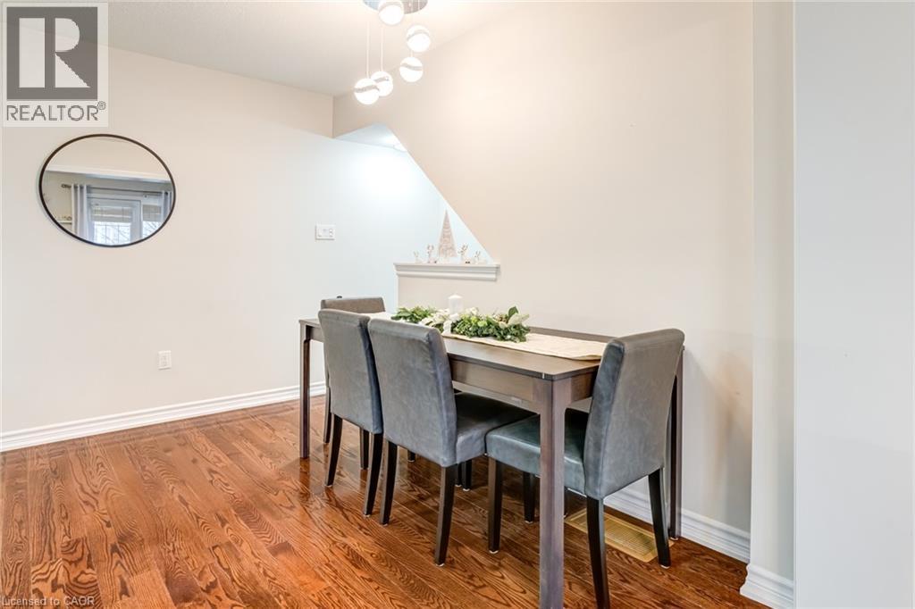 Dining area featuring rich wood-finish flooring, white baseboards, and a contemporary multi-bulb chandelier - 7 Sirente Drive Unit# 11, Hamilton, ON - Indoor Photo Showing Dining Room