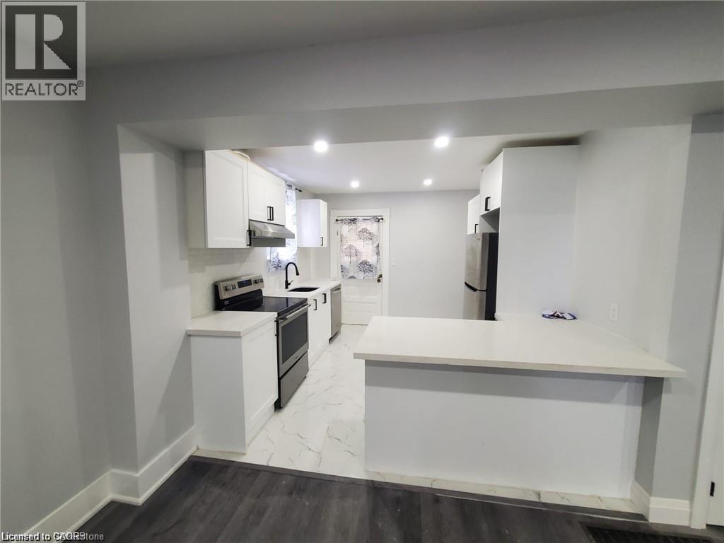 Modern kitchen featuring white cabinetry, light-toned countertops, stainless steel appliances, and recessed lighting - 94 Brook Street, Simcoe, ON - Indoor Photo Showing Kitchen