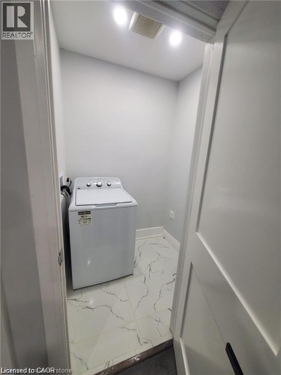 Dedicated laundry area featuring a top-load washing machine, recessed lighting, and white tile flooring with dark veining - 94 Brook Street, Simcoe, ON - Indoor Photo Showing Laundry Room