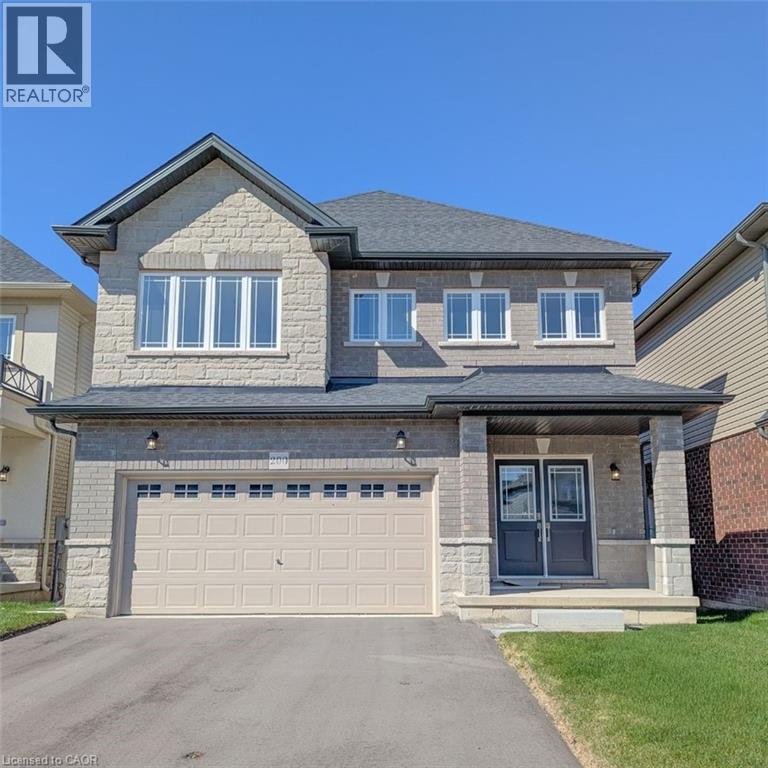 Brick and stone facade residence featuring a double-door entry with sidelights, an attached two-car garage, and multiple large windows - 200 Cittadella Boulevard, Hamilton, ON