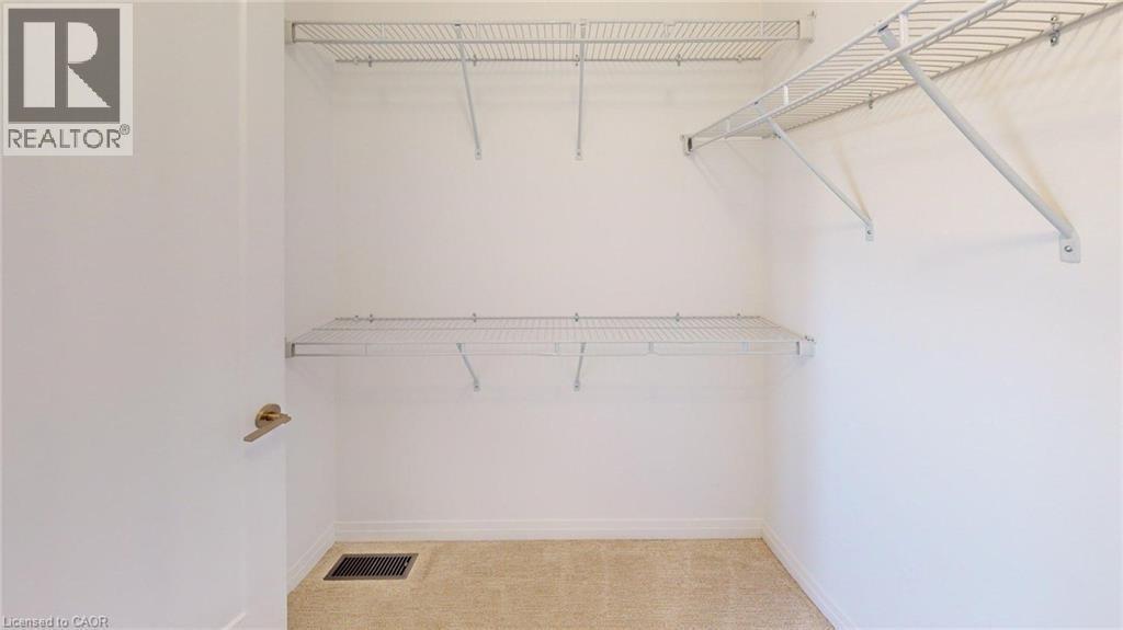 Walk-in closet featuring wire shelving, white walls, and light-colored carpet - 200 Cittadella Boulevard, Hamilton, ON
