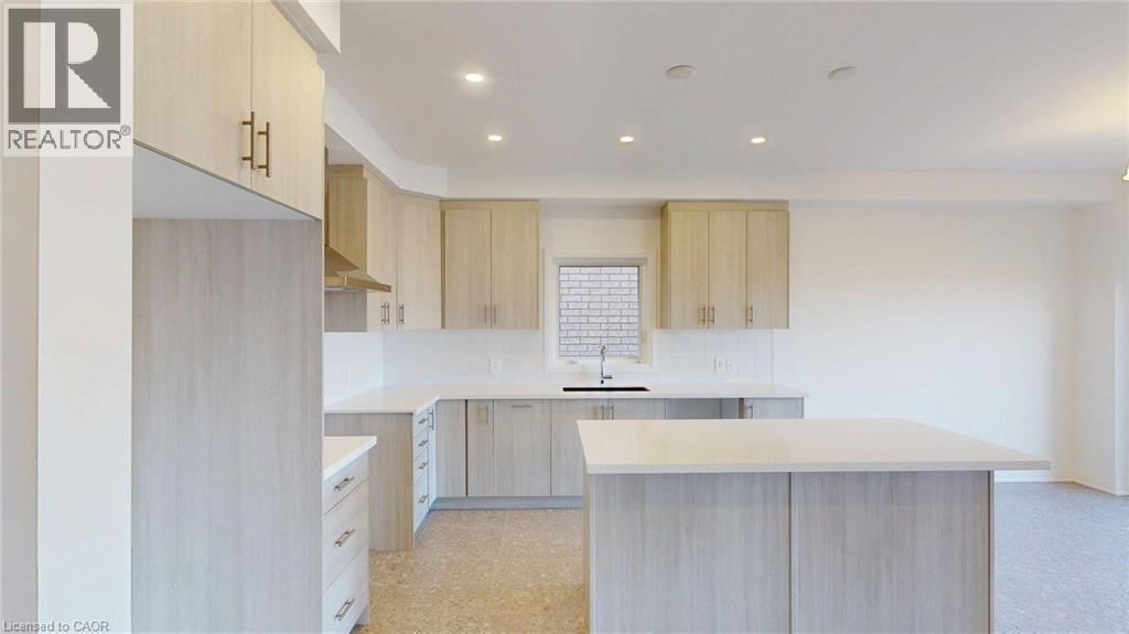 Kitchen featuring light wood-finish cabinetry, white countertops, a central island, recessed lighting, and a stainless steel sink with a black faucet - 200 Cittadella Boulevard, Hamilton, ON