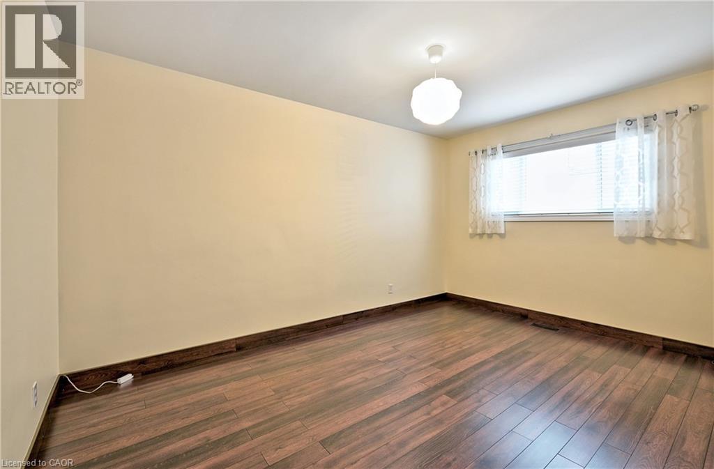 Room featuring wood-finish flooring, light-toned walls, and a ceiling-mounted light fixture - 1476 Barton Street E Unit# 2, Hamilton, ON