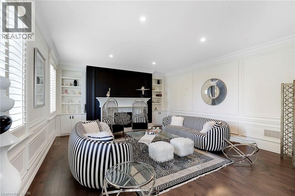 Spacious room featuring rich wood-finish flooring and extensive white wall paneling - 6195 Milburough Line, Burlington, ON - Indoor Photo Showing Living Room