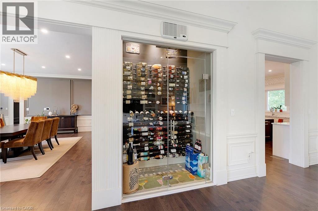 Built-in glass-enclosed wine cellar featuring extensive bottle storage - 6195 Milburough Line, Burlington, ON - Indoor