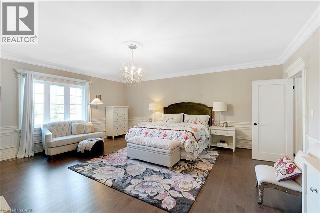 Spacious room featuring dark wood-finish flooring, white paneling, and crown molding - 6195 Milburough Line, Burlington, ON - Indoor Photo Showing Bedroom