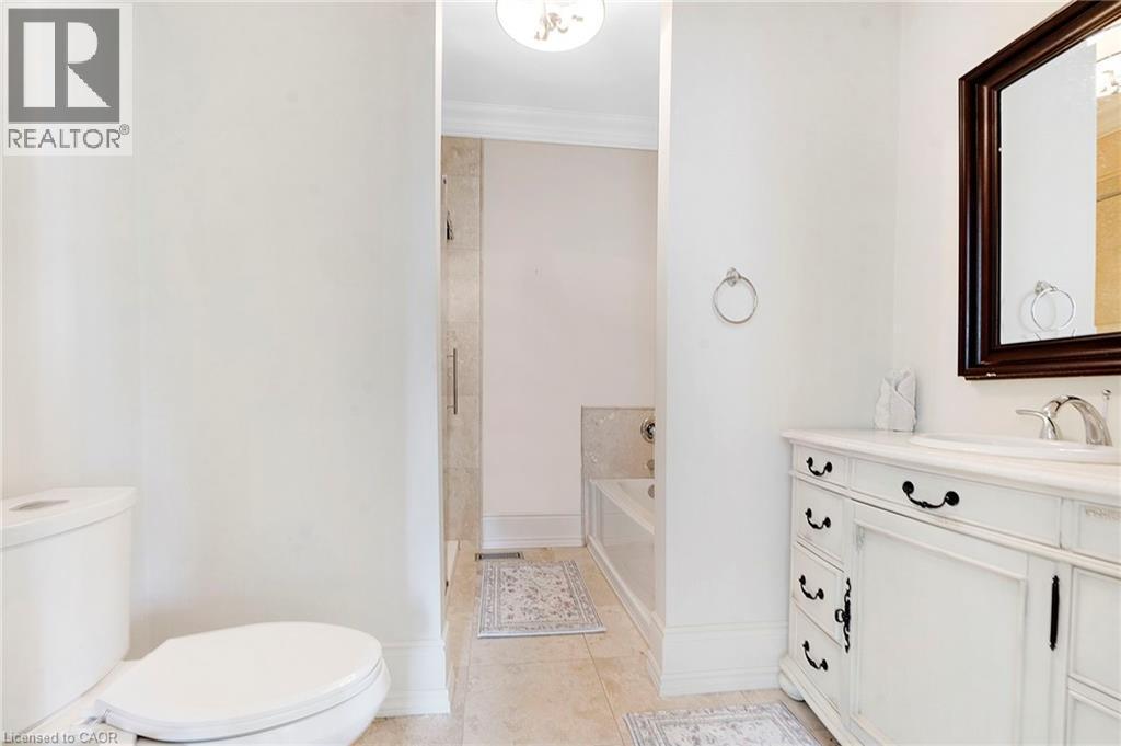 Bathroom featuring a white vanity with a light-toned countertop, an undermount sink, and a dark framed mirror - 6195 Milburough Line, Burlington, ON - Indoor Photo Showing Bathroom