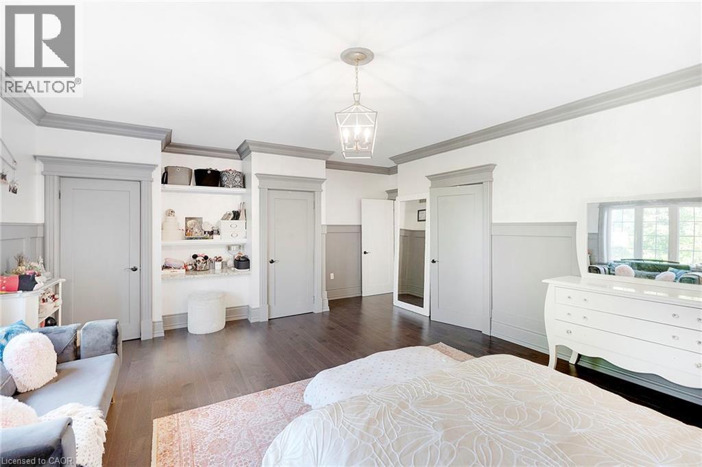 Spacious room featuring dark wood-finish flooring and light grey wainscoting - 6195 Milburough Line, Burlington, ON - Indoor Photo Showing Bedroom