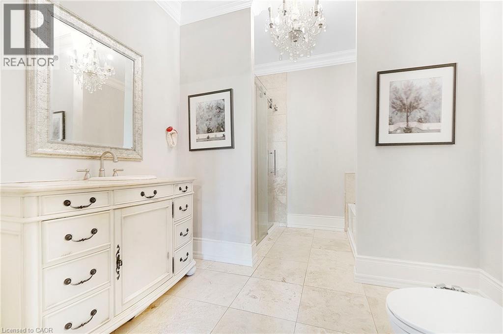 Bathroom featuring a vanity with an integrated sink, a framed mirror, and a crystal chandelier - 6195 Milburough Line, Burlington, ON - Indoor Photo Showing Bathroom