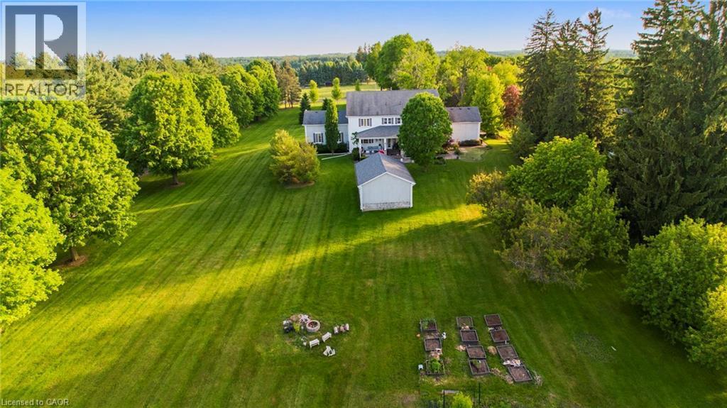 Expansive green lawn with mature trees and a detached outbuilding - 6195 Milburough Line, Burlington, ON - Outdoor With View